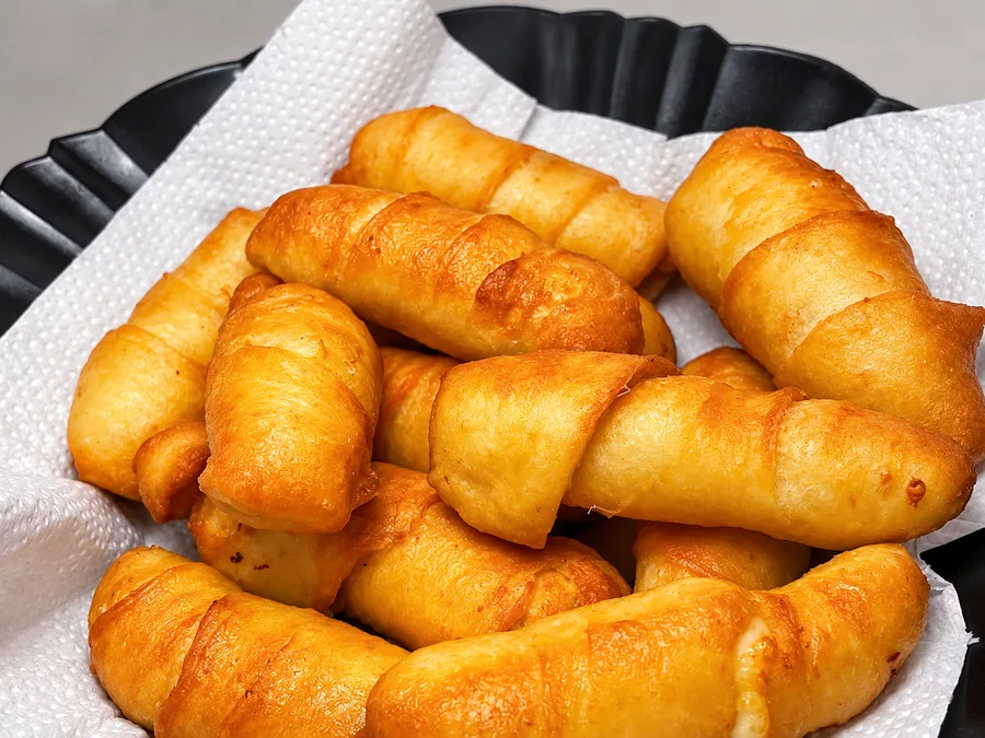 Porção de tequeños dourados recheados com queijo da Merecumbé